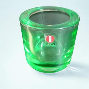 Vihreä Iittalan lasinen tuikkukippo paksusta kirkkaasta lasista vaalealla taustalla