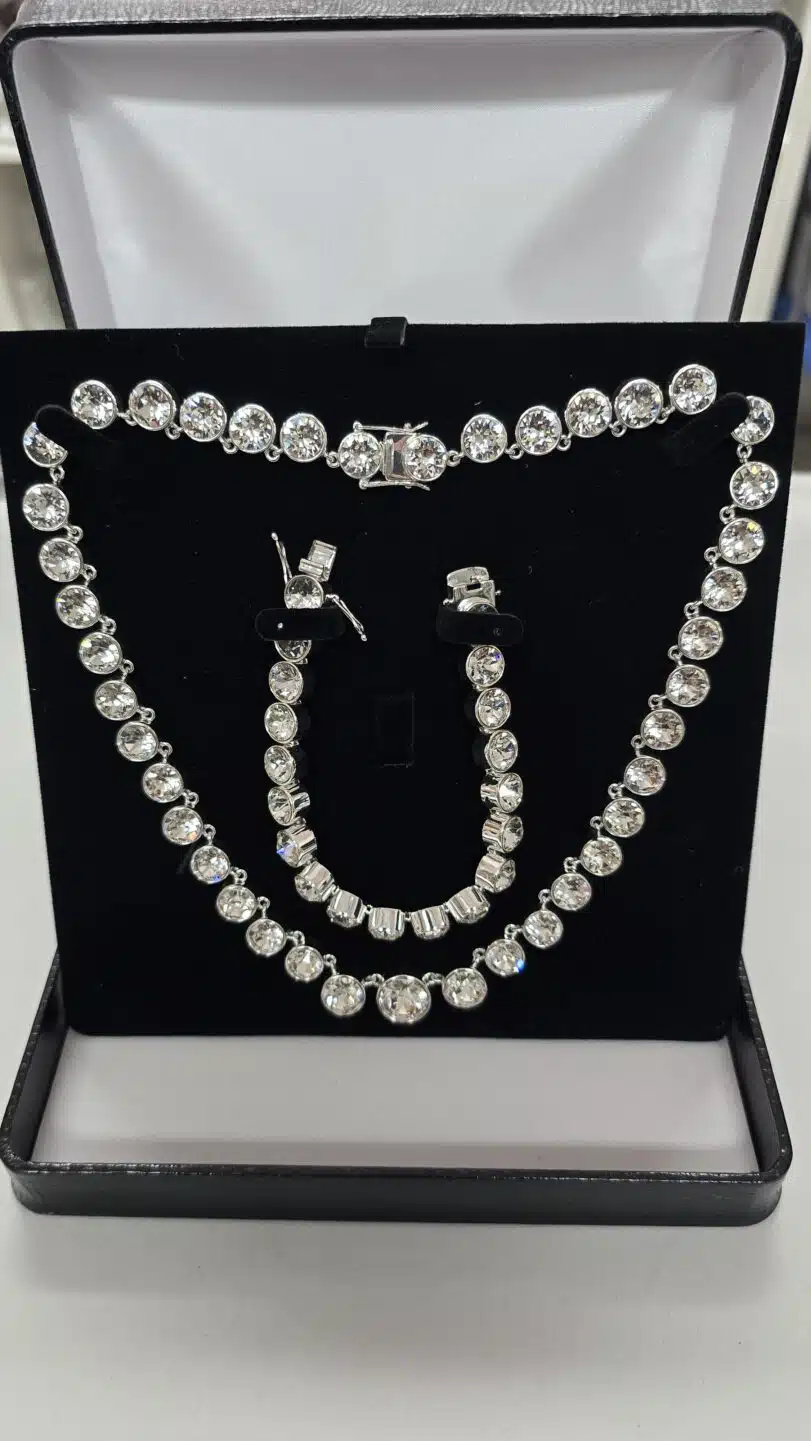 Näyttävä Swarovski-kristallikaulakoru ja rannekoru korurasiassa mustaa samettitaustaa vasten.