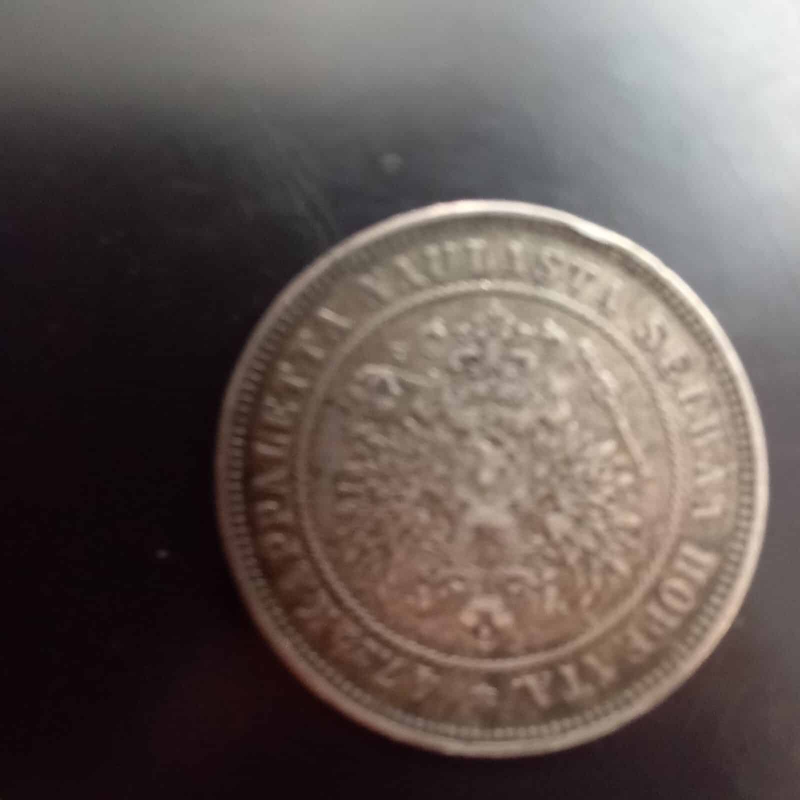 Suomen 2 markan hopeakolikko vuodelta 1874 kuvattuna läheltä tummalla taustalla