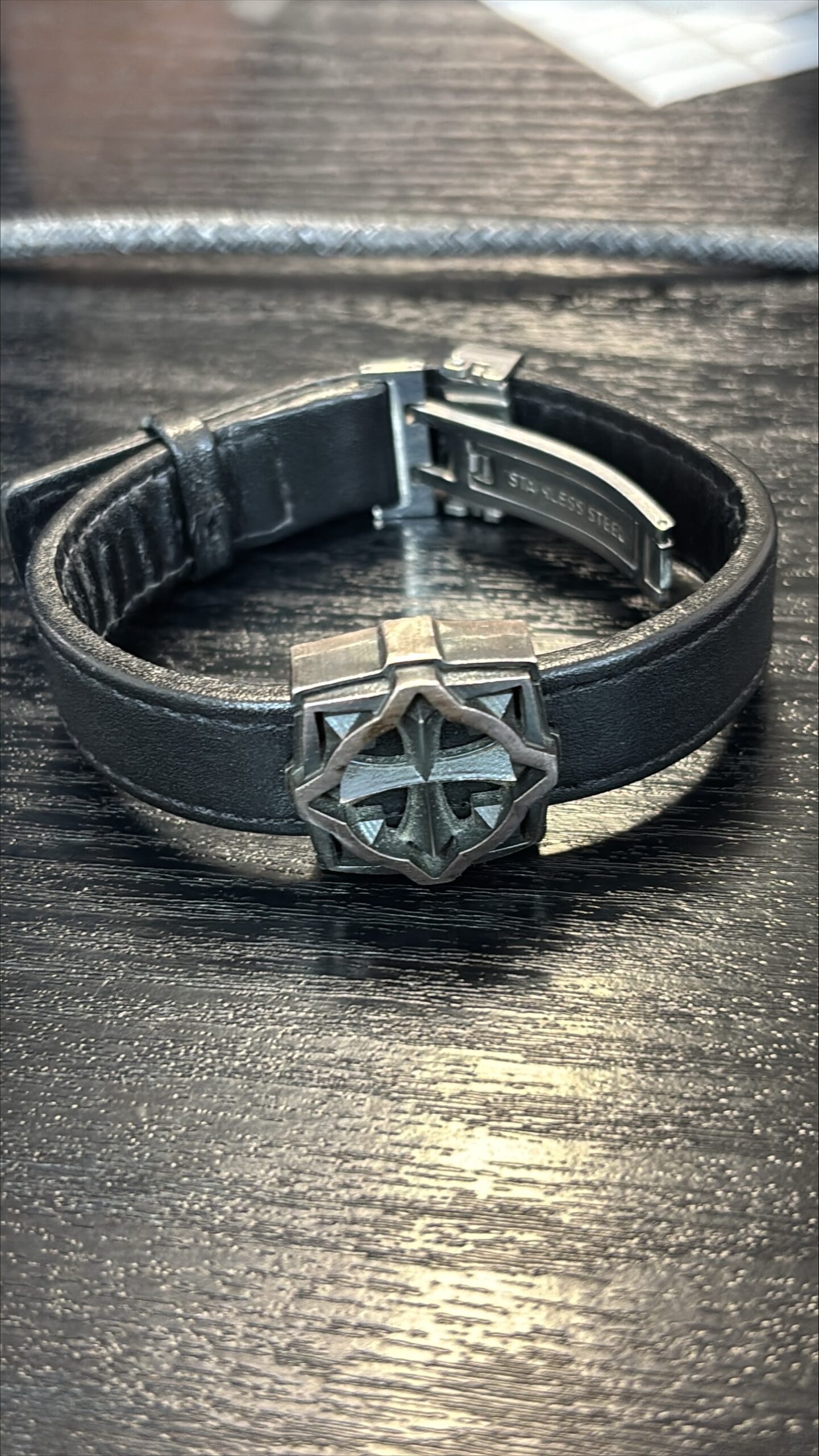 Musta nahkaranneke metallisella koristeella ja solkilukolla.