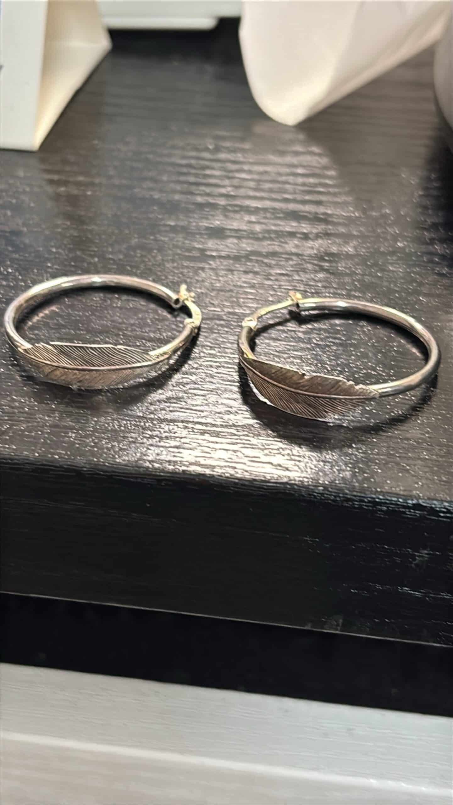 Rengaskorvakorut kuvioidulla pinnalla hopeansävyisestä metallista.