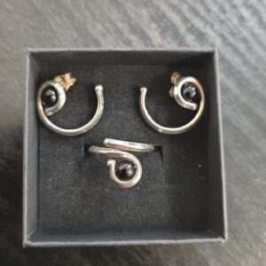 Hopeinen design-korusetti mustilla kivillä